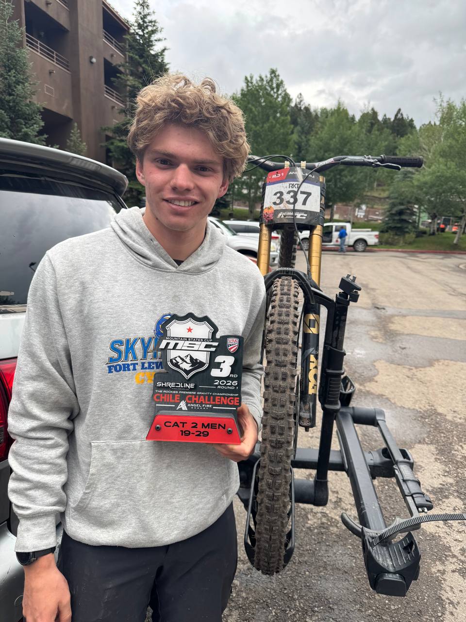 Me holding my 3rd place Mountain States Cup trophy next to my bike